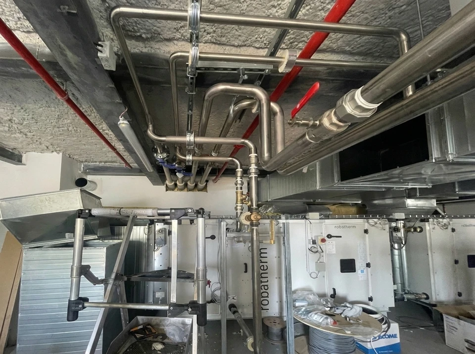Intérieur industriel avec réseau complexe de canalisations métalliques isolées thermiquement