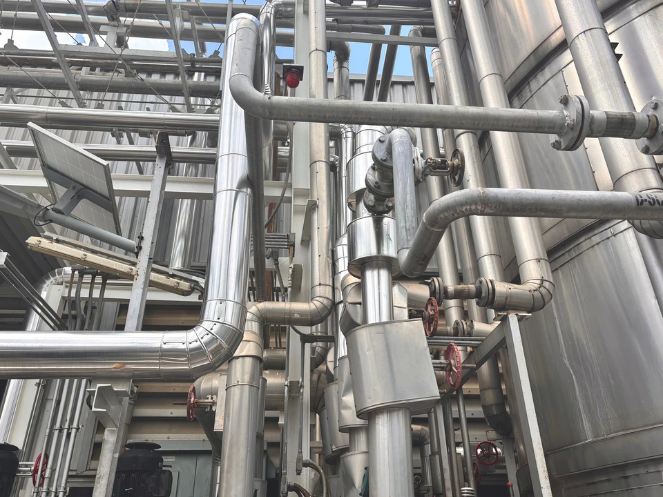 Intérieur industriel avec réseau de tuyauterie gaz, tubes jaunes DN200 avec coudes et réducteurs, vannes de sectionnement à opercule, régulateur de pression gaz, filtre séparateur AME/ROME monté en rack